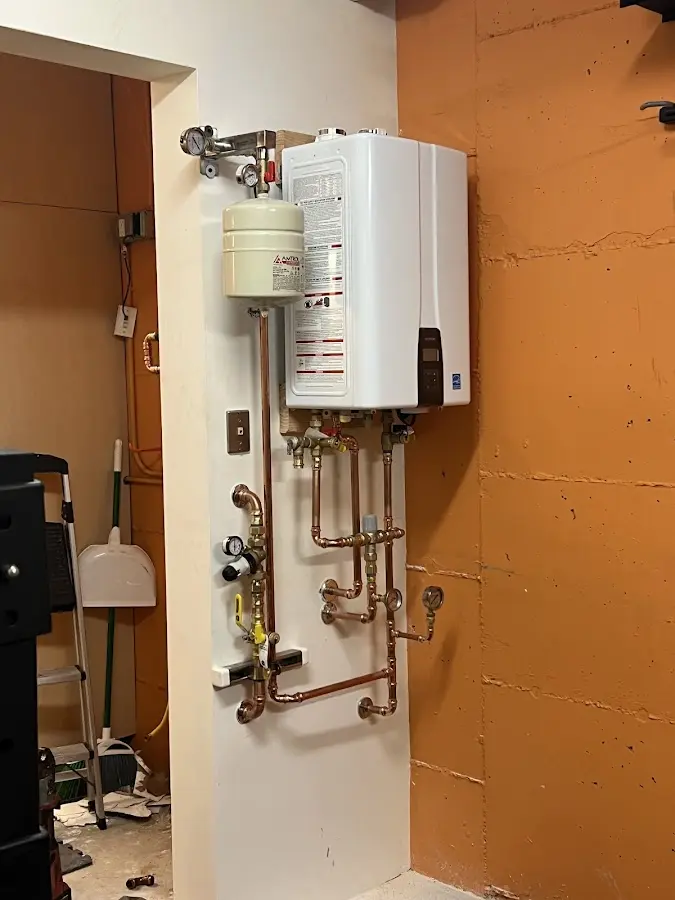 Plumbing technician inspecting water heater connections in Woodlawn